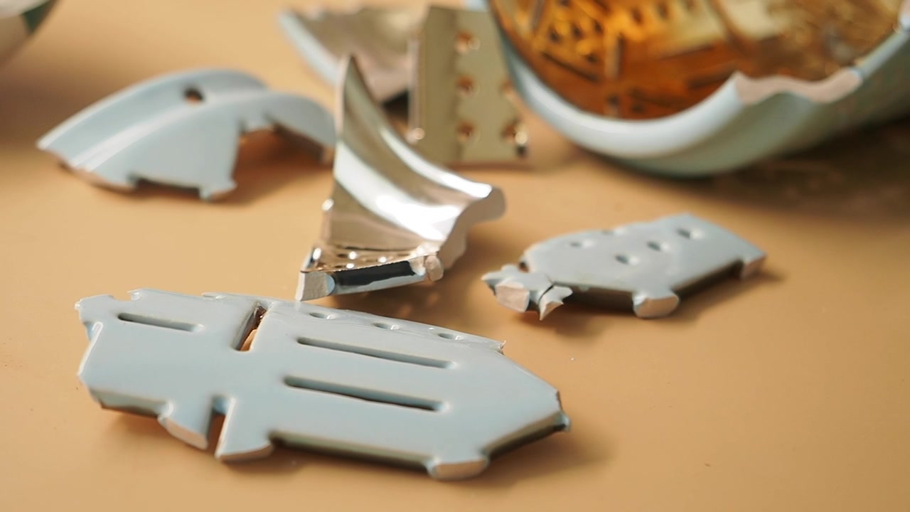 Frammenti di un oggetto decorativo in ceramica su un tavolo.