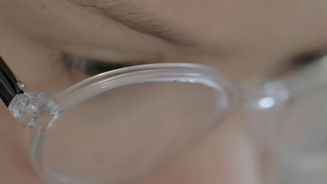 그가 책을 읽고 있을 때 안경을 쓴 어린 소년의 얼굴에 극단적인 근접 촬영