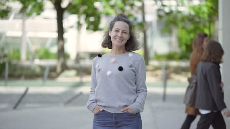 una hermosa mujer de mediana edad sonriendo posando al aire libre.