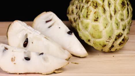 custard apple and slices displayed on a table