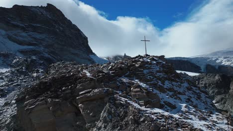cerca cristiano católico religioso jesús cristo cruzar rocoso glaciar cima de la montaña drone aéreo saas tarifa alpes suizos suiza otoño cielo azul soleado mediodía capa nublada círculo a la derecha