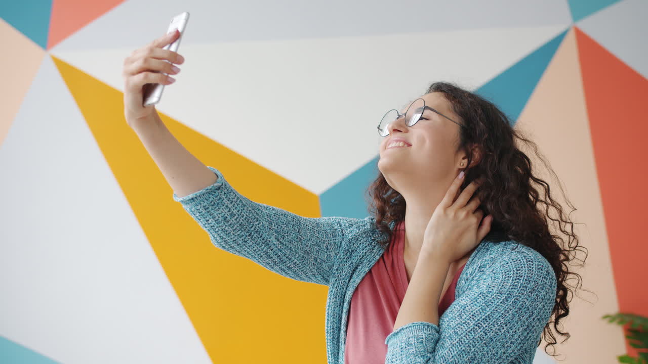 Woman Taking Selfie in Front of Colorful Wall