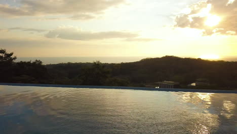 Hermosa-Piscina-Infinita-En-Una-Mansión-Tropical-Durante-La-Puesta-De-Sol