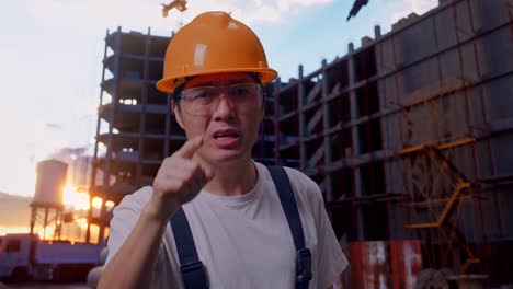 un trabajador asiático gritando a la cámara en el sitio de construcción