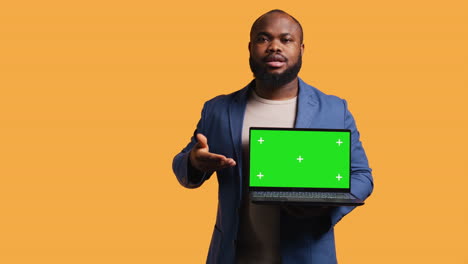 Portrait-of-man-doing-influencer-marketing-using-green-screen-laptop