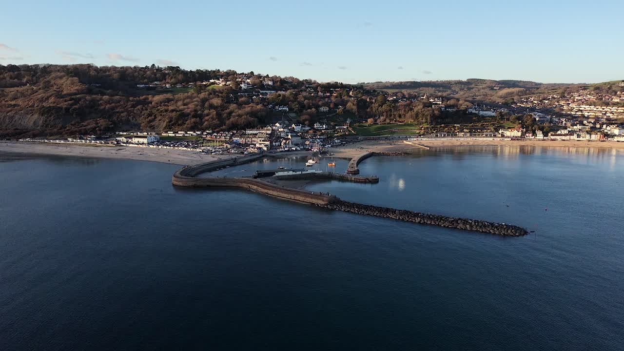 Dronebillede af Lyme Regis, Dorset, Storbritannien, der viser stranden, havnen og den berømte Cobb.
