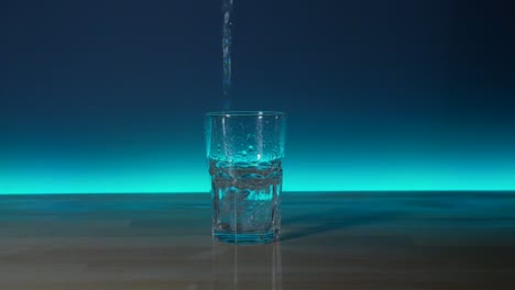 Glass-to-be-filled-with-water-until-it-spills-over-the-table