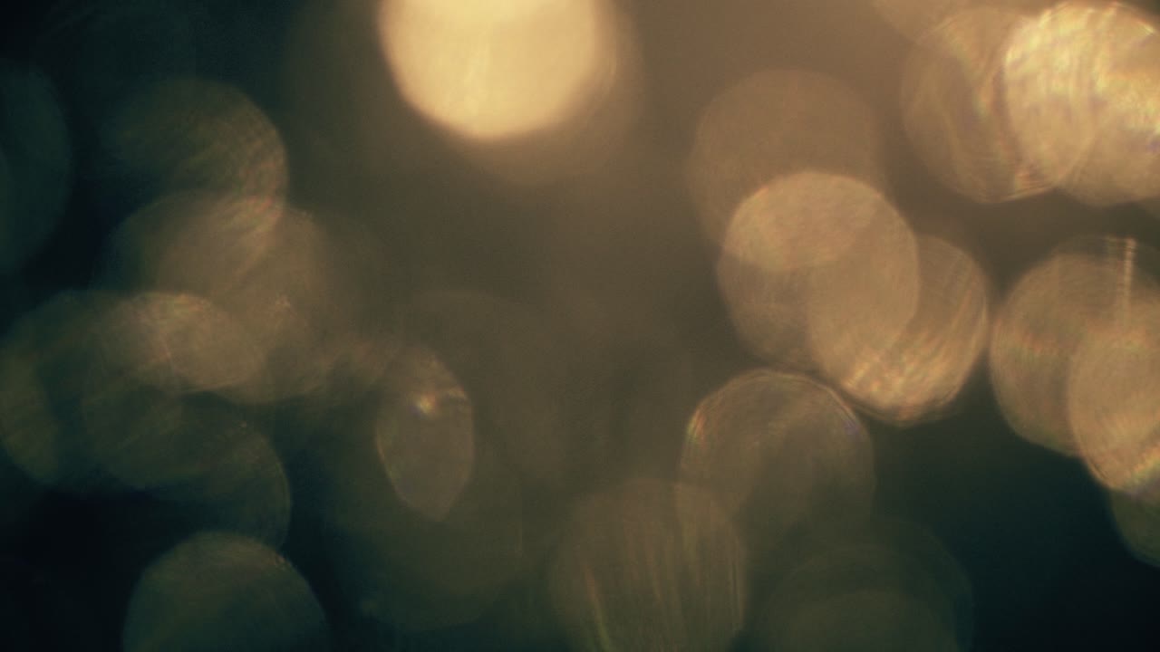 Abstract Golden Bokeh Lights Moving on Dark Background