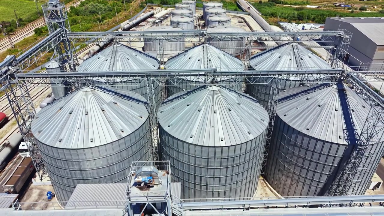 Industrial storage facility with large silos seen from above during the day in a rural area