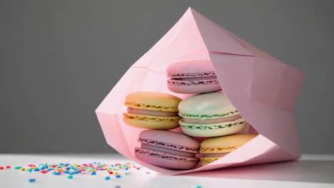 colorful macarons in a pink paper bag
