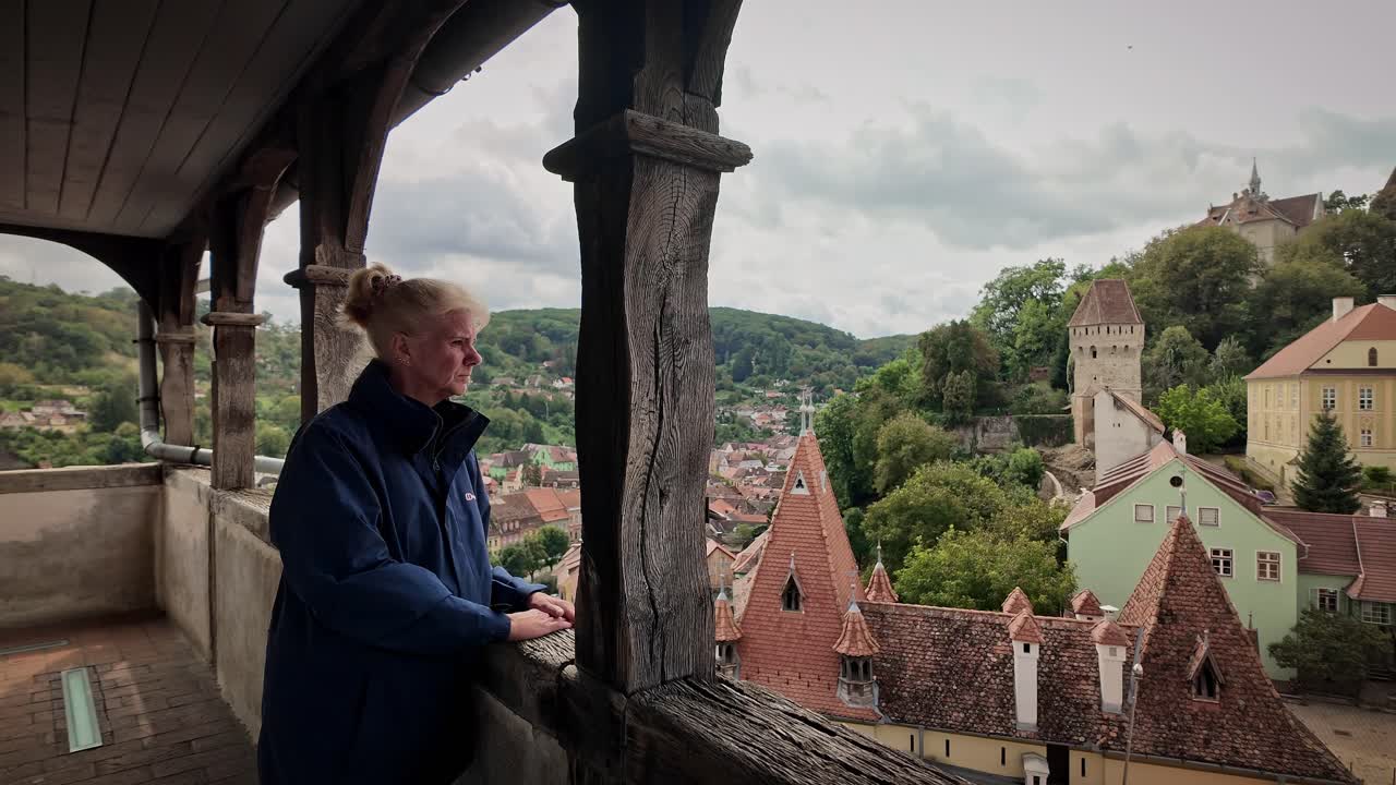 Tourist enjoys panoramic views over medieval Sighisoara cityscape