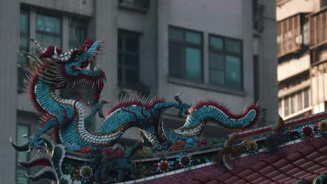 roof decorative sculptures at longshan temple with a modern building on the background