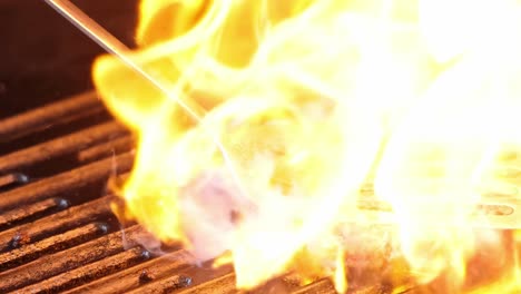 watch as a burger patty is seared with intense flames on a grill, creating a fiery cooking spectacle.