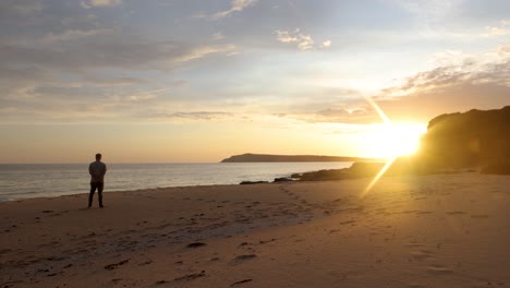 Un-Hombre-Parado-En-La-Playa-Y-Mirando-Una-Hermosa-Puesta-De-Sol-En-Australia