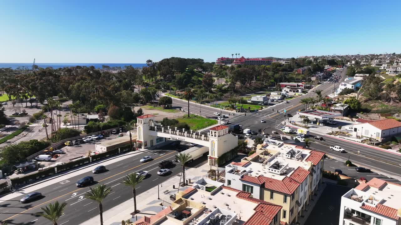 Cars Driving In The Road With Dana Point Footbridge And Watermen's Plaza In Dana Point, California, USA