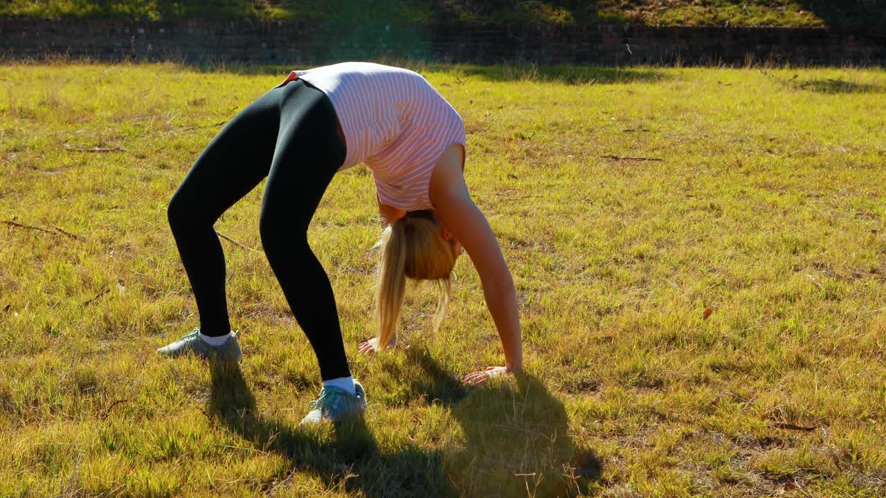 mujer realizando un ejercicio de estiramiento durante una carrera de obstáculos