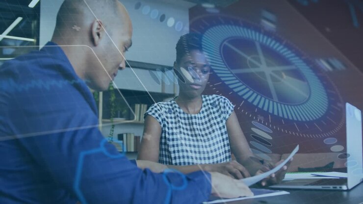 Man sliding paper to woman, office team reviewing docs for edits while circular graphic over laptop