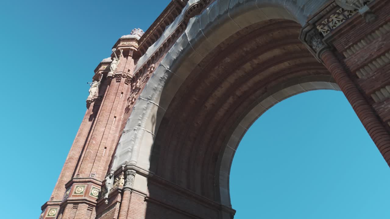 el ornamentado arco de ladrillo del arco del triunfo contra un cielo despejado en barcelona, españa