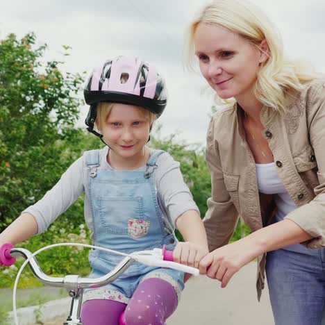 Mama-Bringt-Ihrer-Tochter-Das-Fahrradfahren-Bei-1