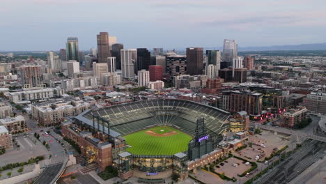 push in drone shot of downtown denver and coors field at dusk