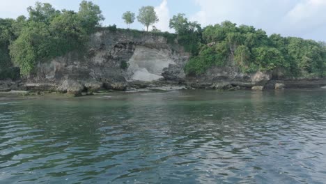 una toma de drone de baja altitud de agua contaminada llena de basura flotante en el agua tropical turquesa de bali, indonesia