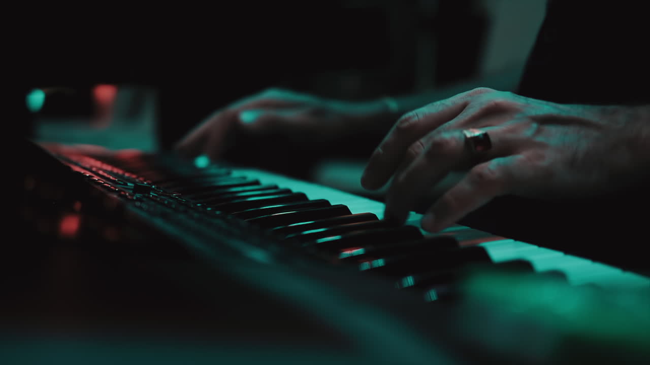 Musicians playing at a wedding. Man is playing synthesizer. Stage lights