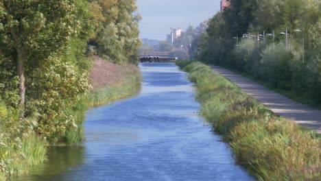 Gente-Caminando-Por-El-Paseo-Marítimo-A-Lo-Largo-Del-Gran-Canal-Con-Humo-De-La-Bomba-Incendiaria-En-El-Fondo-Durante-El-Otoño-En-Dublín,-Irlanda