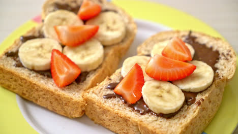 whole wheat bread toasted with fresh banana, strawberry and chocolate for breakfast