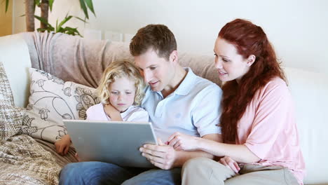 Familia-Sentada-Junto-Con-Una-Computadora-Portátil