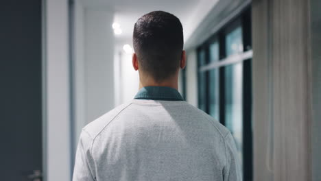 man walking in a modern office corridor