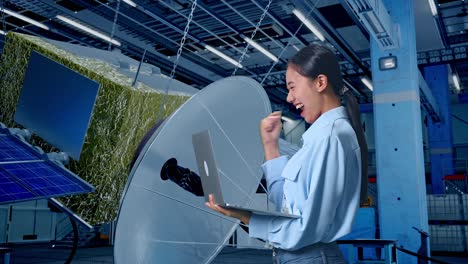 mujer ingeniera emocionada revisando el proyecto de satélite en la computadora portátil