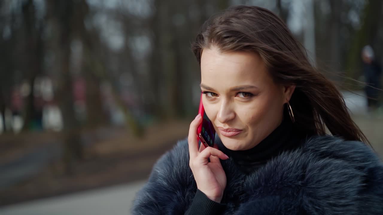 Woman talking on phone. Attractive woman talking on cellphone in park