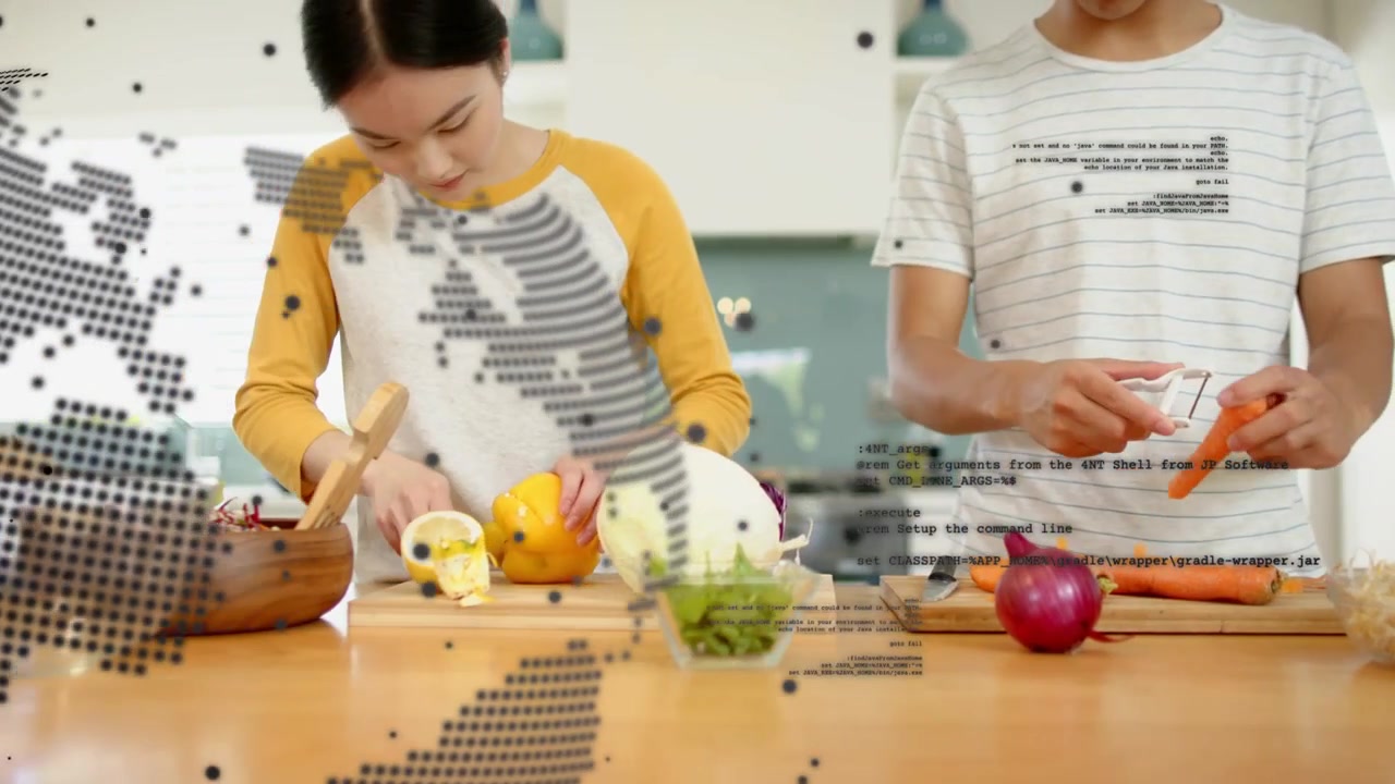左の女性が黄色い野菜を刻むために手を伸ばし、右の男性はニンジンを剥いている。地球儀のオーバーレイが料理を覆い隠している。
