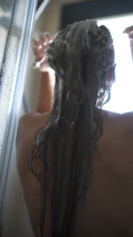 mujer lavándose el cabello en la ducha