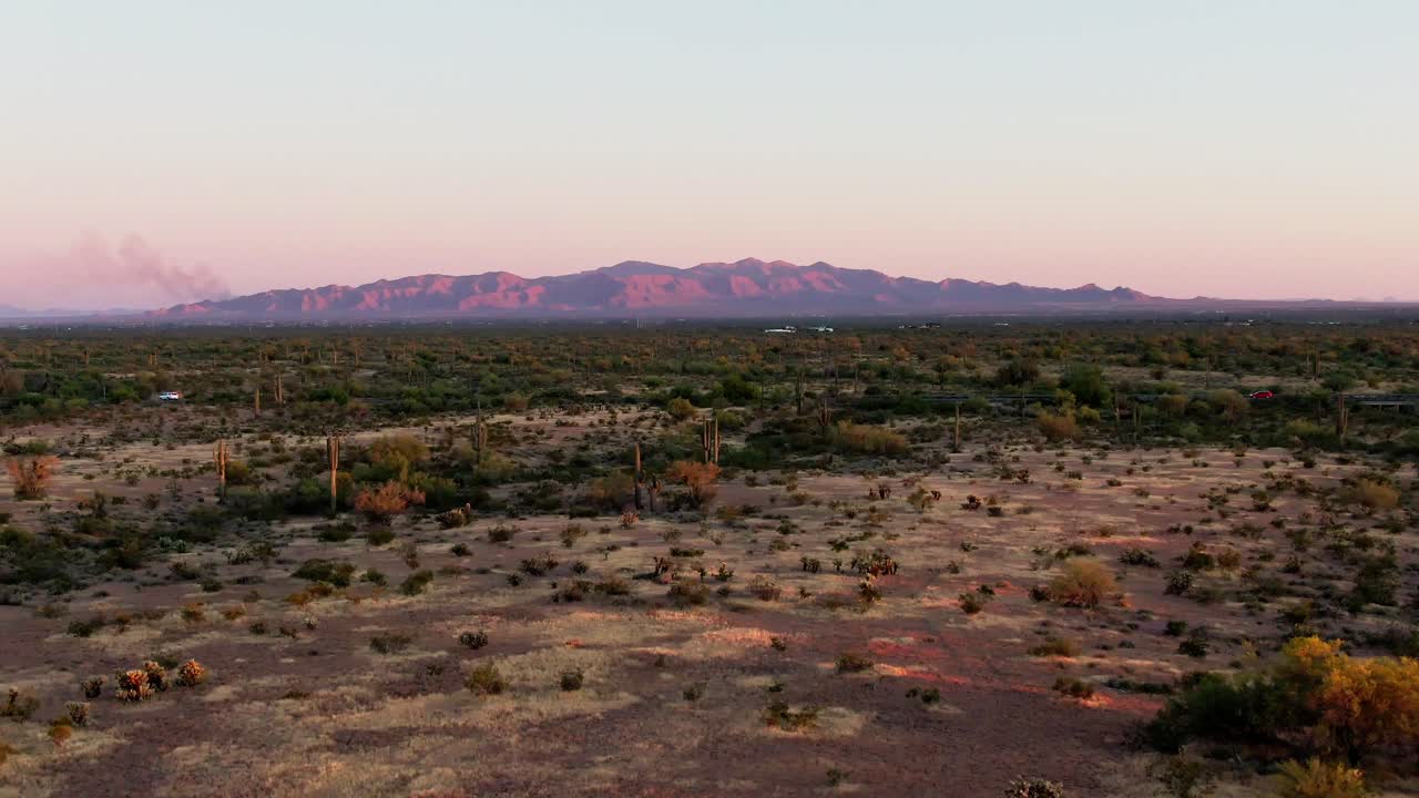 vasto paisaje desértico con cactus y la cordillera del gran cañón al atardecer