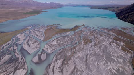 Luftflug-über-Den-Geflochtenen-Godley-Fluss,-Der-In-Richtung-Der-Mündung-Des-Tekapo-sees-Fliegt,-Mit-Den-Bergen-Im-Hintergrund