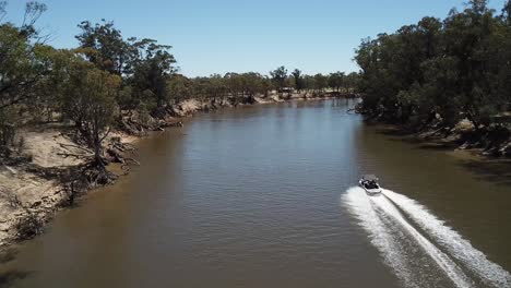 drone aerial over a muddy river in australia camping in bush