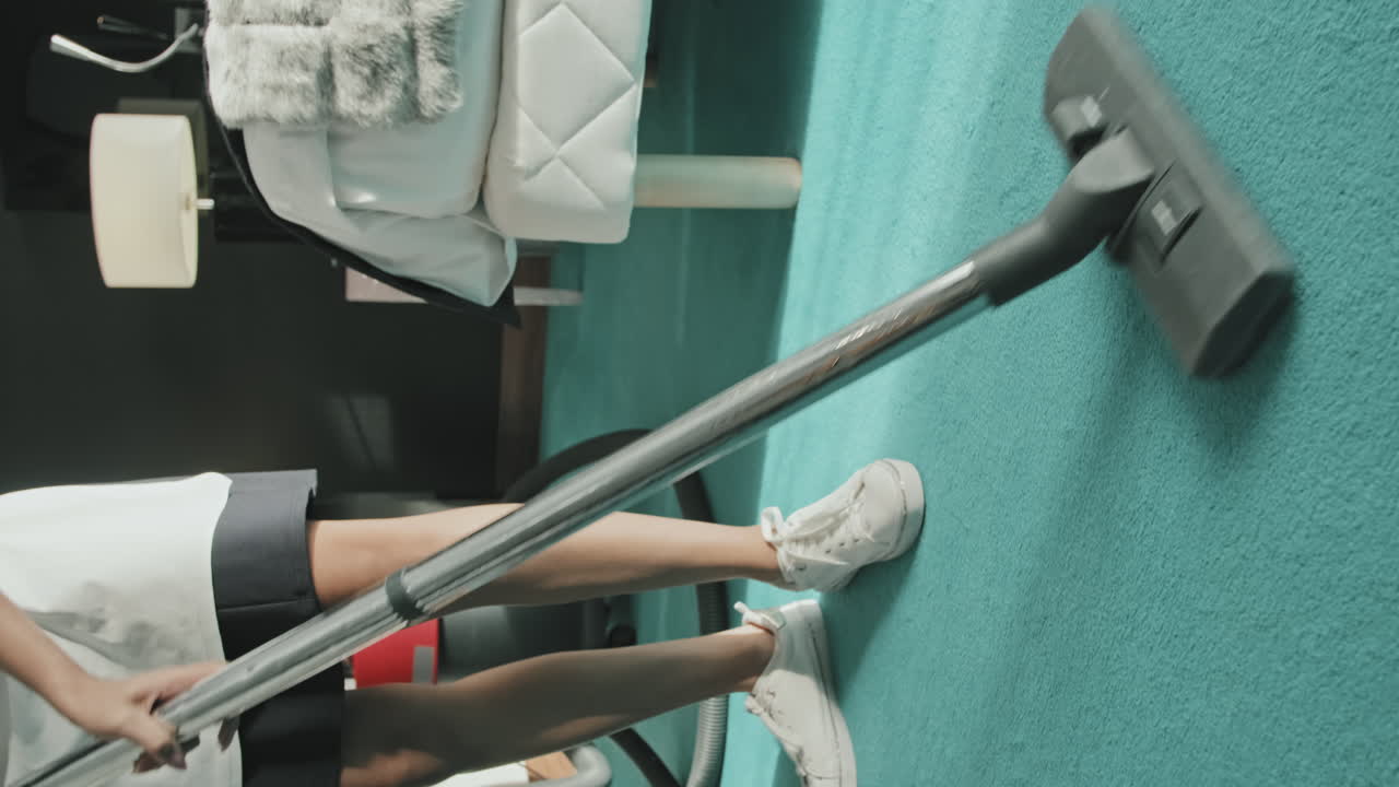Housekeeper Doing Hoovering in Hotel Room