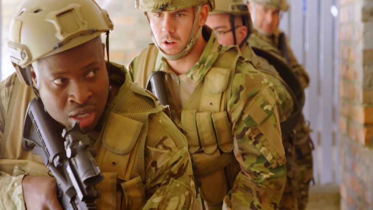 vista frontal de soldados militares de raza mixta caminando con rifles durante el entrenamiento militar 4k