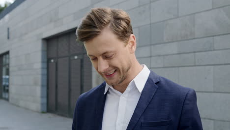 close up surprised businessman reading good news on smartphone at city street