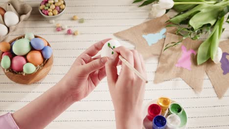 Happy Easter holiday. Coloring eggs top view. Woman preparing for Easter, painting and decorating eggs. Christian celebration, family traditions.