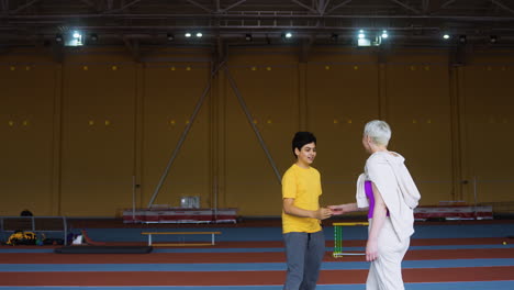 Senior-woman-greeting-boy-indoors