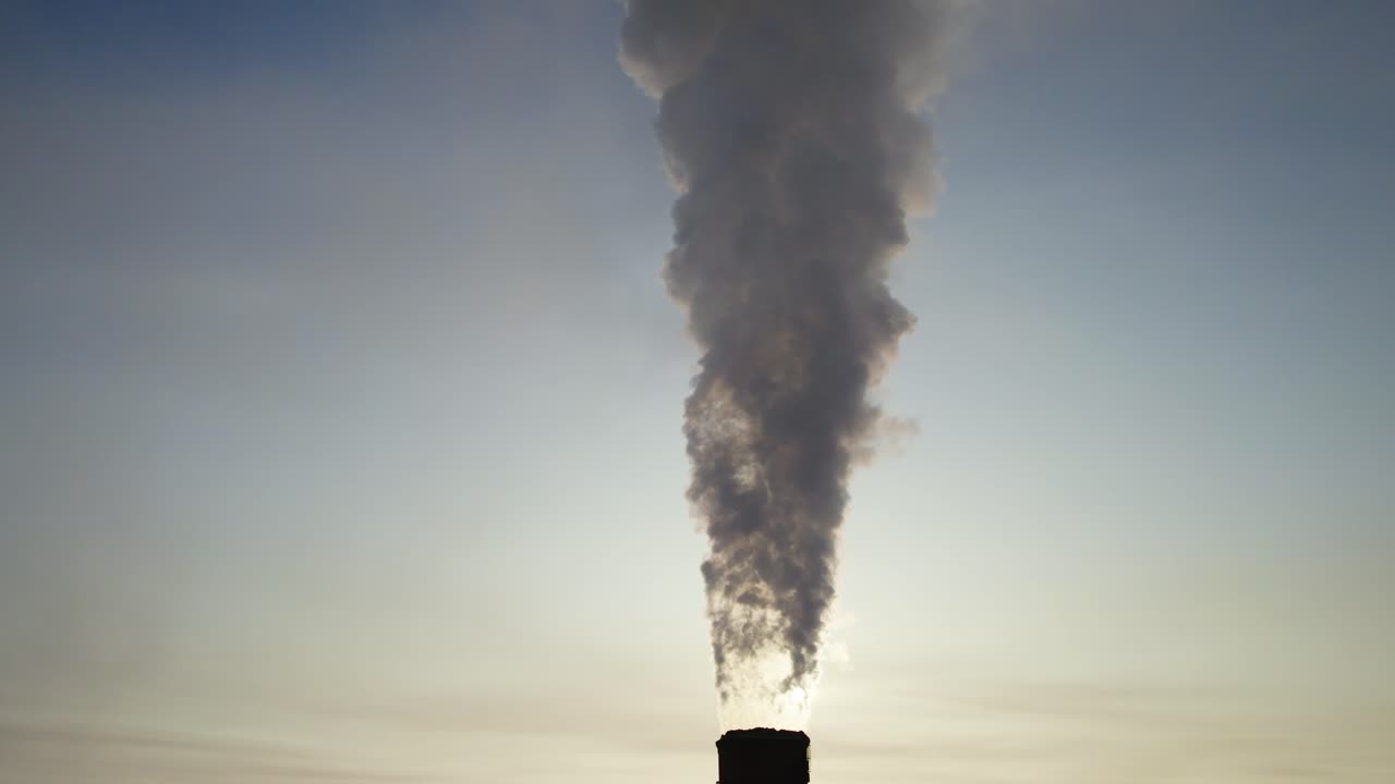 Smoke rising from a chimney at sunrise/sunset