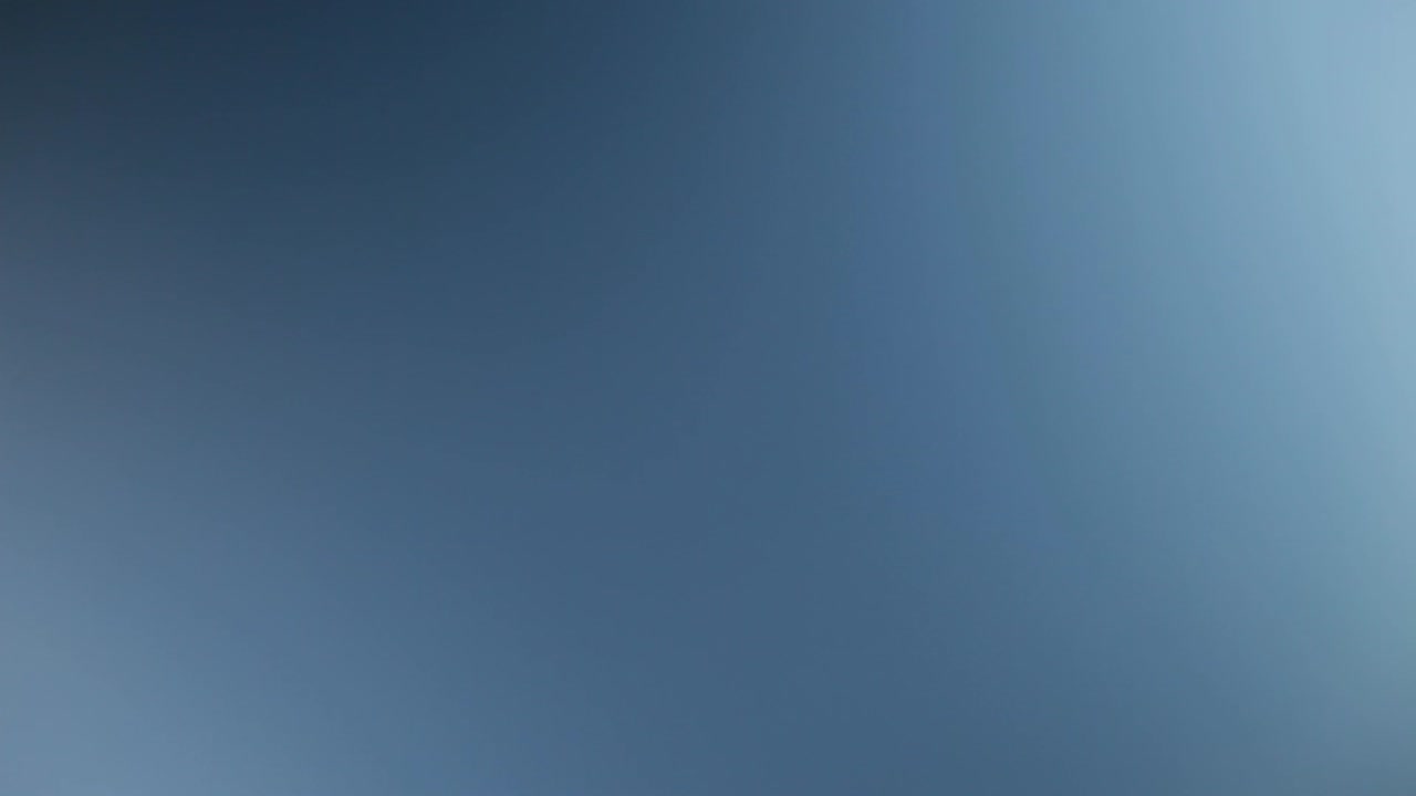 primer plano de una pala de turbina eólica contra un cielo azul claro, transmitiendo movimiento y energía renovable