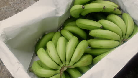 Delightful-Shot-of-a-Hand-Placing-Fresh-Bananas-in-a-Basket