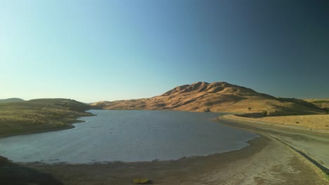 a drone reveal of paicines reservoir highlights its peaceful waters and surrounding farmland, a hidden gem in california’s countryside.