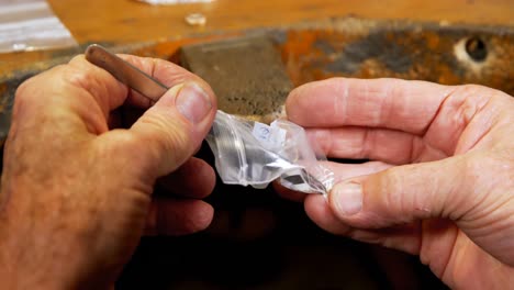 goldsmith working at desk in workshop 4k