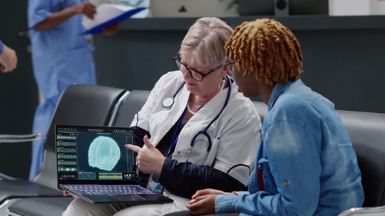 Doctor showing brain scan to patient on laptop