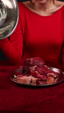 raw steak presentation with woman in red dress