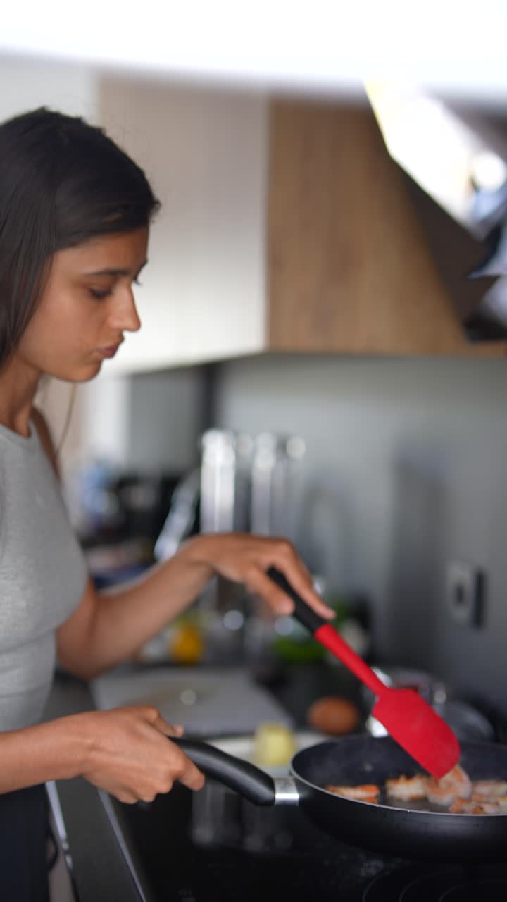 mujer cocinando camarón en una cocina
